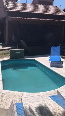 a blue chair sitting next to a swimming pool at Complejo Norte in Merlo