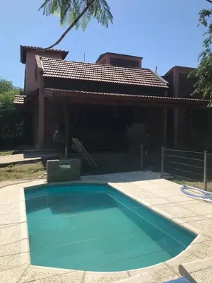 a swimming pool in front of a house at Complejo Norte in Merlo