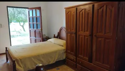 a bedroom with a bed and a large wooden cabinet at El Cortijo Apart - Hotel in Merlo