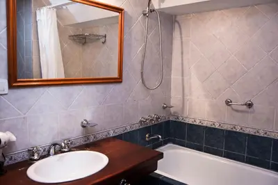 a bathroom with a sink and a tub and a mirror at El Cortijo Apart - Hotel in Merlo