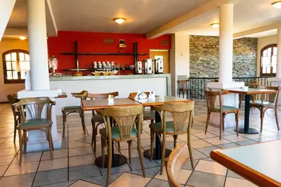a restaurant with wooden tables and chairs and a counter at El Cortijo Apart - Hotel in Merlo