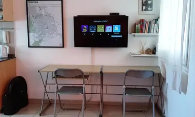 a table with two chairs and a tv on a wall at Departamento Fragueiro 2414 terraza exclusiva in Cordoba