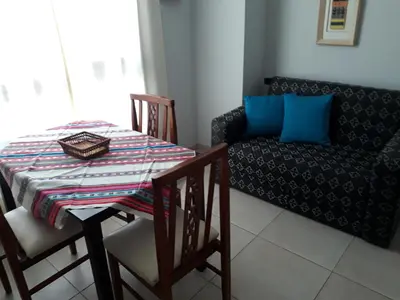 a dining room with a table and a couch at CALIDO-Departamento 1 dormitorio amueblado excelente ubicacion in Río Cuarto