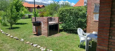 a brick barbecue in a yard with a table and chairs at Ayres Serranos in Merlo