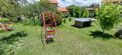 a swing set in the grass in a yard at Ayres Serranos in Merlo