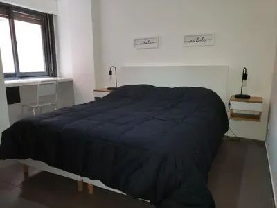 a bedroom with a bed with a black comforter at Alquiler Temporario en Nueva Córdoba! in Cordoba