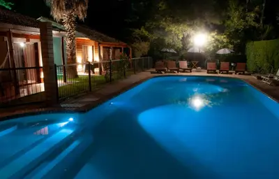 a blue swimming pool at night with a house at Mont Blanc in Villa General Belgrano