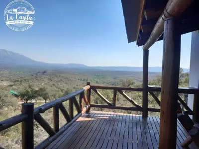 a wooden deck with a view of the savanna at Cabaña de Montaña, La Casita Mina Clavero CBA in Mina Clavero