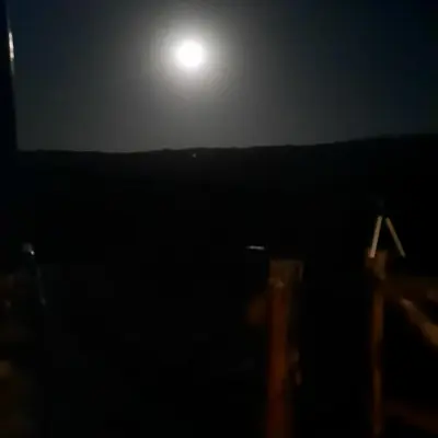 a full moon rising over the ocean at night at Cabaña de Montaña, La Casita Mina Clavero CBA in Mina Clavero