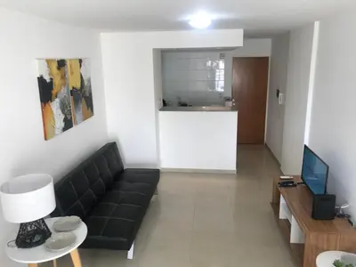 a living room with a black couch and a television at Jardines del Boulevard 3, Nueva cordoba in Cordoba