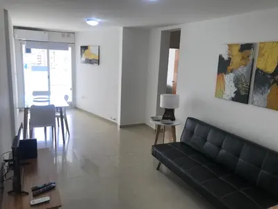 a living room with a black couch and a table at Jardines del Boulevard 3, Nueva cordoba in Cordoba