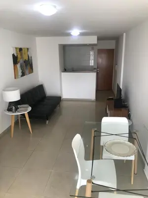 a living room with a black couch and a table at Jardines del Boulevard 3, Nueva cordoba in Cordoba