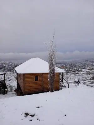 a wooden cabin with snow on top of it at Cabañas Los Álamos in Villa Carlos Paz