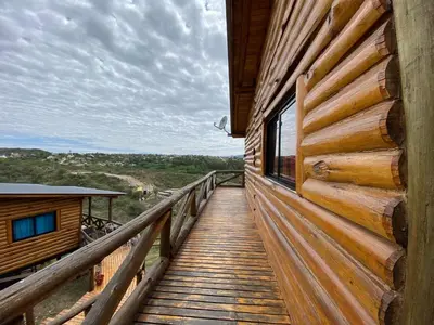 a wooden walkway leading to a cabin with a window at Cabañas Los Álamos in Villa Carlos Paz