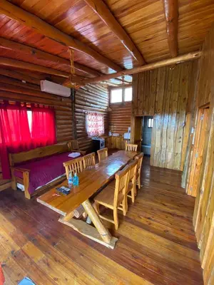 a dining room with a wooden table and chairs at Cabañas Los Álamos in Villa Carlos Paz