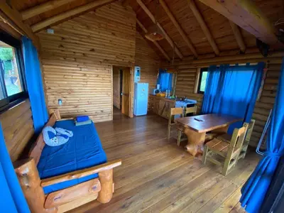 a log cabin with a table and a dining room at Cabañas Los Álamos in Villa Carlos Paz