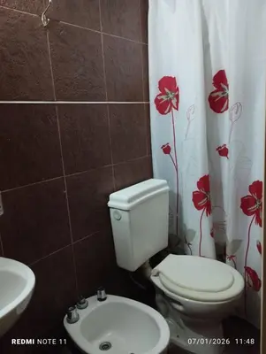 a bathroom with a toilet and a sink at Mini Complejo Familiar Roque in Mina Clavero