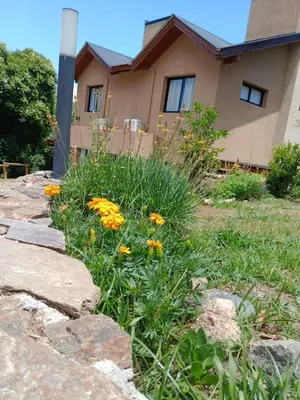 a garden with flowers in front of a house at Complejo Cerro Negro VGB in Villa General Belgrano