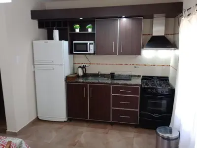 a kitchen with brown cabinets and a white refrigerator at Complejo Cerro Negro VGB in Villa General Belgrano