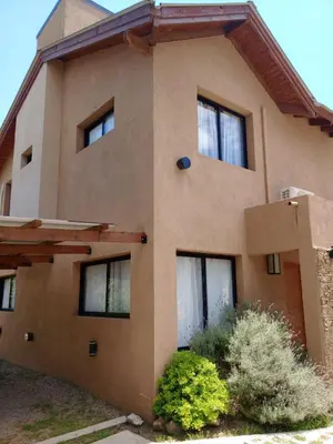 a large house with some bushes in front of it at Complejo Cerro Negro VGB in Villa General Belgrano