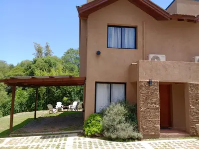 a house with a porch and a patio at Complejo Cerro Negro VGB in Villa General Belgrano