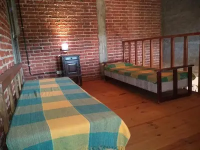 a bedroom with two beds and a brick wall at Casa Monte in Villa Icho Cruz