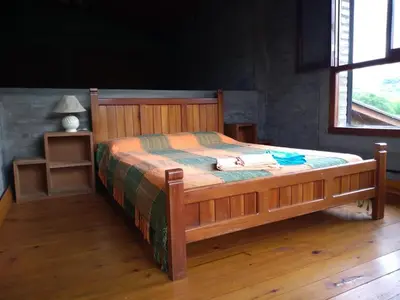 a bedroom with a wooden bed with a wooden floor at Casa Monte in Villa Icho Cruz