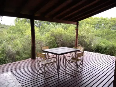 a table and chairs on a wooden deck at Casa Monte in Villa Icho Cruz