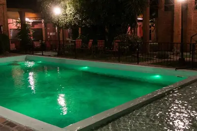 a swimming pool at night with green lights in it at Posada Alpenrose Neu in Villa Carlos Paz