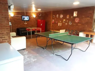 a living room with a ping pong table in it at Posada Alpenrose Neu in Villa Carlos Paz