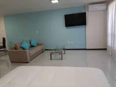 a living room with a couch and a flat screen tv at Miralejos 7 Turquesa in Villa Carlos Paz