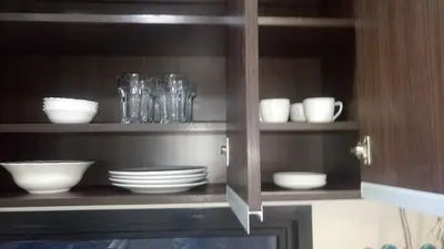 a cabinet filled with plates and bowls and glasses at Miralejos 7 Turquesa in Villa Carlos Paz