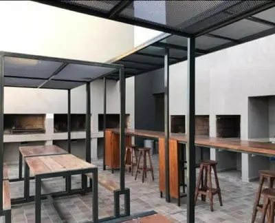 a kitchen with tables and stools in a room at Miralejos 7 Turquesa in Villa Carlos Paz