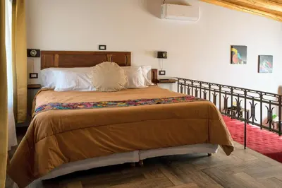 a bedroom with a large bed with a wooden headboard at Tantasiña Cabañas Suites de Montaña in San Javier