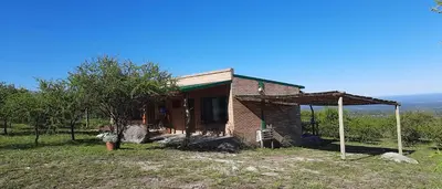a small brick house in the middle of a field at Tantasiña Cabañas Suites de Montaña in San Javier