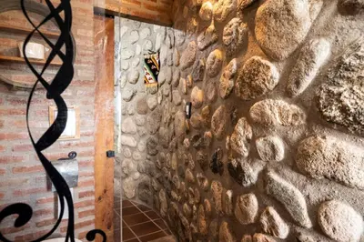 a stone wall in a room with a hose at Tantasiña Cabañas Suites de Montaña in San Javier