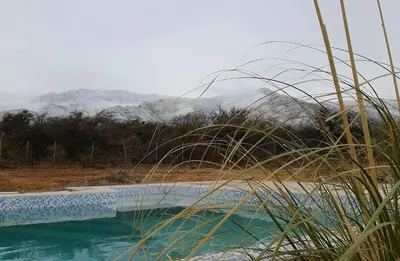 a pool of water with mountains in the background at Tantasiña Cabañas Suites de Montaña in San Javier