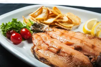 a plate of food with fish and chips and vegetables at Hotel de la Cañada in Cordoba