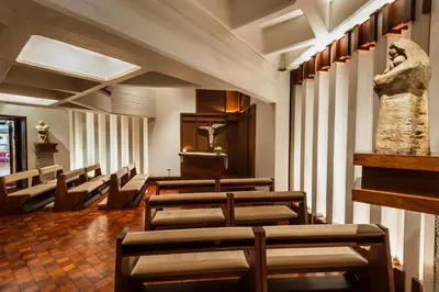 a row of chairs in a waiting room with a statue at Hotel de la Cañada in Cordoba