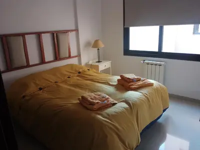 a bedroom with a yellow bed with two towels on it at Departamento Alberdi in Cordoba