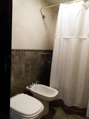 a bathroom with a white toilet and a sink at Departamento Alberdi in Cordoba