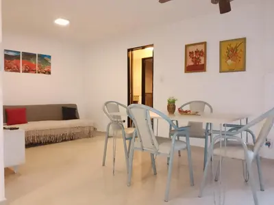 a living room with a table and chairs and a couch at Departamento Alberdi in Cordoba