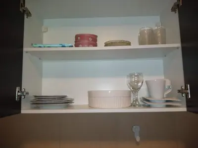 a cupboard with dishes and plates and a wine glass at Departamento Alberdi in Cordoba