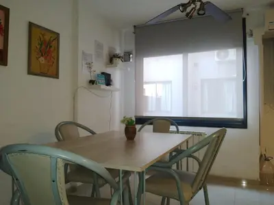 a dining room table with chairs and a window at Departamento Alberdi in Cordoba