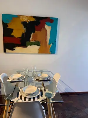 a dining table with chairs and a painting on the wall at Torre Magna II, Nueva Cordoba in Cordoba