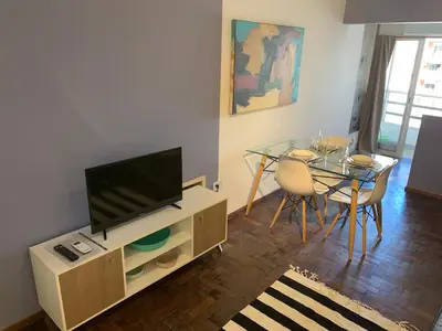 a living room with a television and a dining table at Torre Magna II, Nueva Cordoba in Cordoba