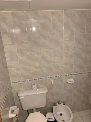 a small bathroom with a toilet and a sink at Torre Magna II, Nueva Cordoba in Cordoba