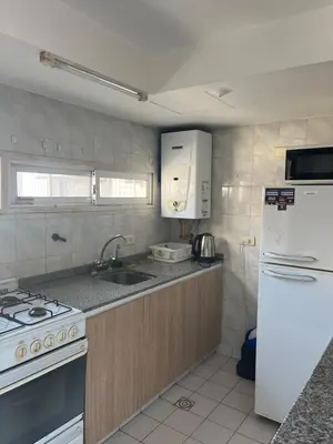 a kitchen with a sink and a stove and a refrigerator at Torre Magna II, Nueva Cordoba in Cordoba