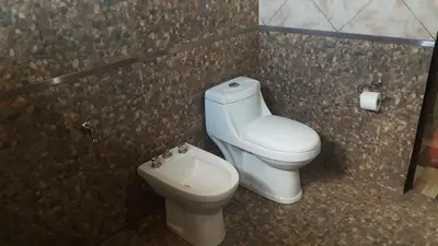 a bathroom with a toilet and a bidet at Luz Alba Cabañas in Mina Clavero