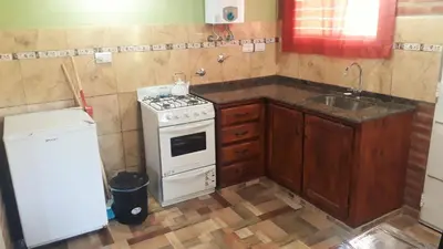a small kitchen with a stove and a sink at Luz Alba Cabañas in Mina Clavero